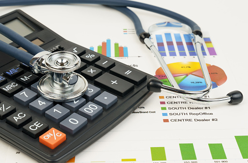 Stethoscope and calculator on charts and graphs. Finance, accounting, statistics, investment, economics of analytical research data. Business company concept.