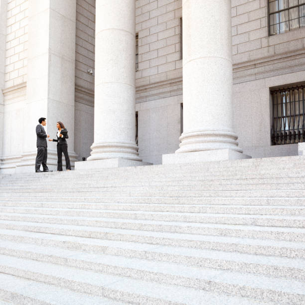 istock Lawyers in Discussion on Courthouse Steps Exterior 1389354836