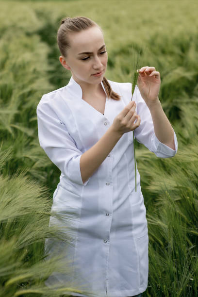 istock Ecologist or biologist in a white coat and glasses examining plants 1389355849