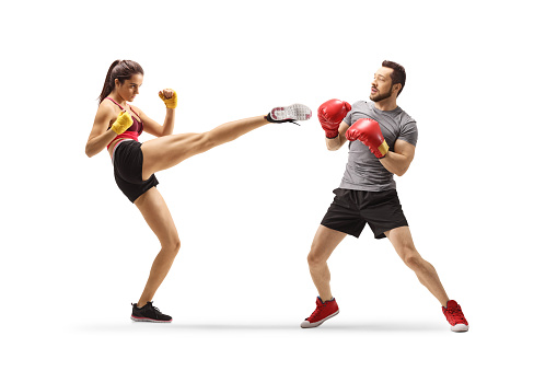 Young man and woman exercising kick box isolated on white background