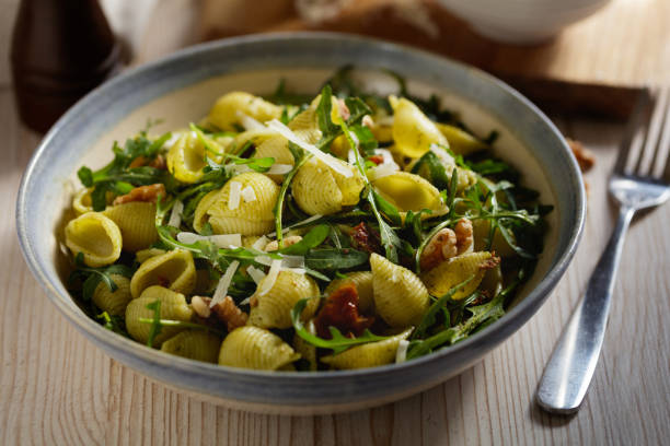 Homemade conchiglie pasta with rocket leaves, sun dried tomatoes and walnut pesto sauce.