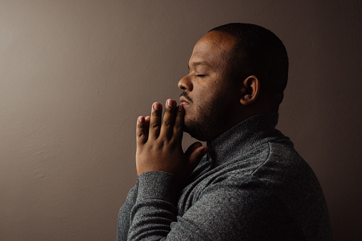 Profile portrait of a black man in prayer