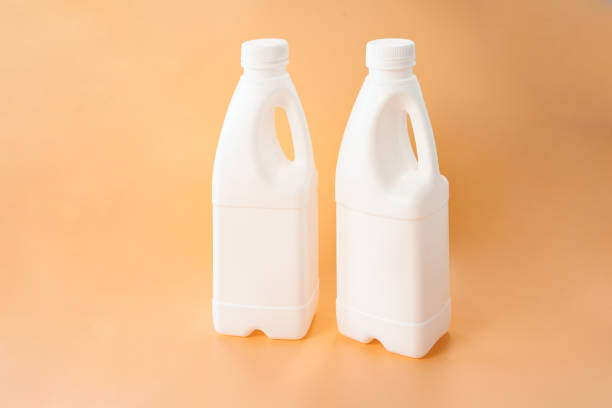 istock Two white plastic bottle with fresh milk with handle on yellow background. Mock up for brand template. Order. Store. Calorie. Vitamin. Mockup. Packaging. Freshness. Healthy Eating. Lactose. Nutrient 1389361663