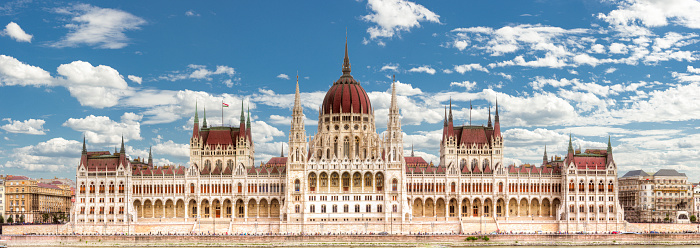 Frontal view of the façade of the Hungarian Parliament building in Budapest, the capital of Hungary in fine summer weather with blue skies and light clouds