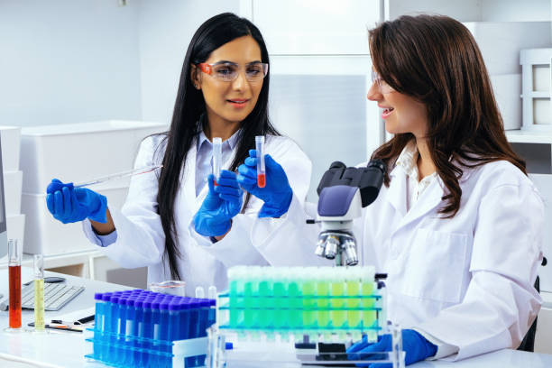 istock Two beautiful young female scientists working in laboratory with test tubes doing some research 1389367324
