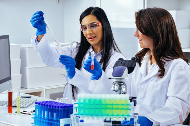 istock Two beautiful young female scientists working in laboratory with test tubes doing some research 1389367335