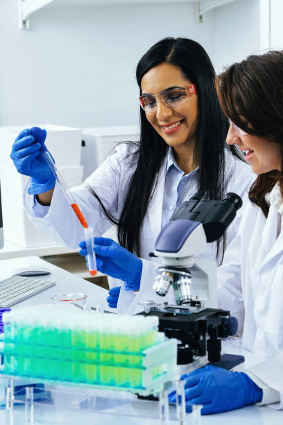 istock Two beautiful young female scientists working in laboratory with test tubes doing some research 1389367364