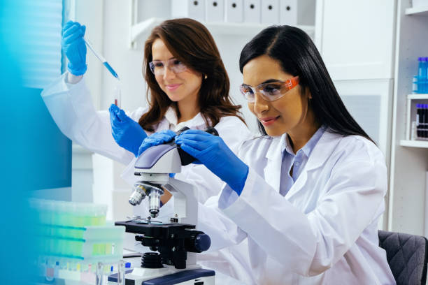 istock Two beautiful young female scientists working in laboratory with test tubes and microscope doing some research 1389367537