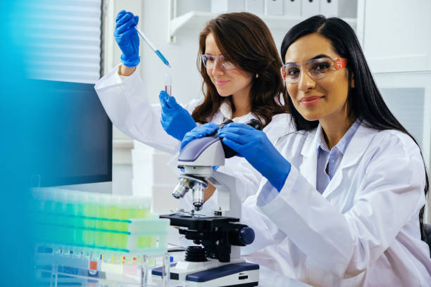 istock Two beautiful young female scientists working in laboratory with test tubes and microscope doing some research 1389367539
