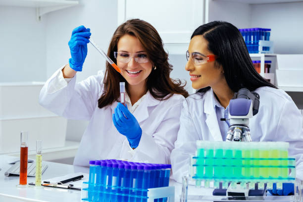 istock Two beautiful young female scientists working in laboratory with test tubes doing some research 1389367571