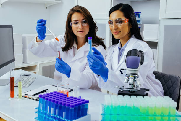 istock Two beautiful young female scientists working in laboratory with test tubes doing some research 1389367598