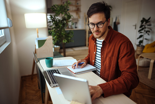 Young man with glasses working from home