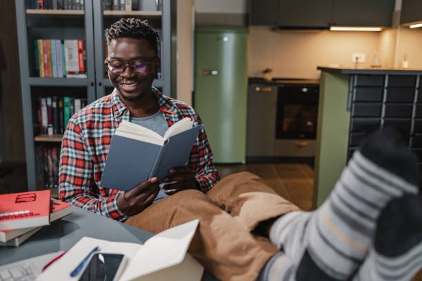 istock African-American man reading a book at home 1389369969
