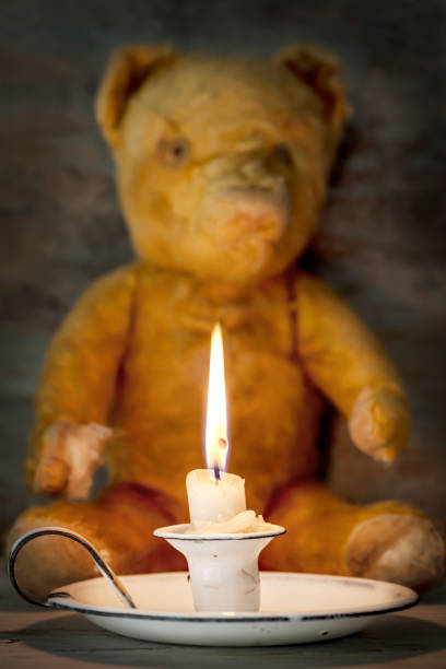 istock Vintage Enamel Candle Holder with Old Teddy Bear Behind 1389370900