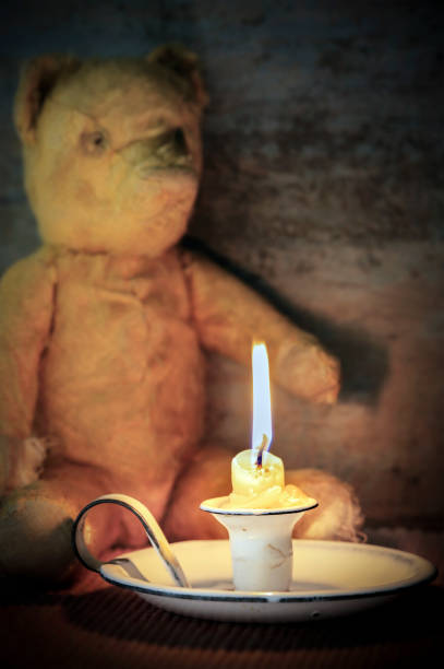 istock Vintage Enamel Candle Holder with Old Teddy Bear Behind 1389370913