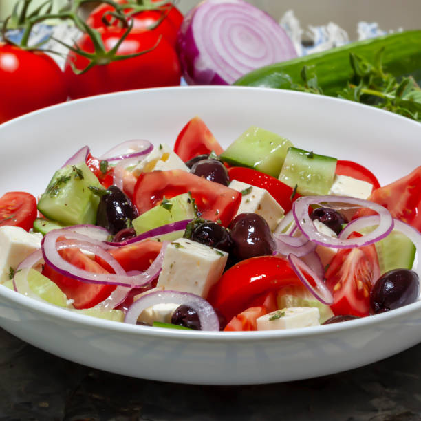 istock Greek Salad in. White Bowl with Ingredients Behind 1389370920