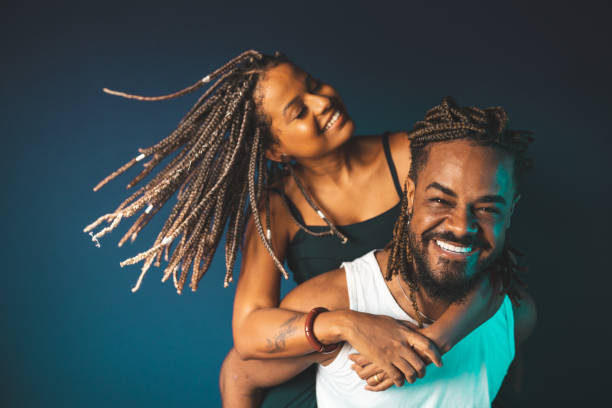 istock Man carrying his girlfriend on his shoulders on blue background 1389372934
