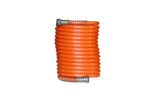 Spiral plastic hose for air compressor with end connectors. White background and copy space