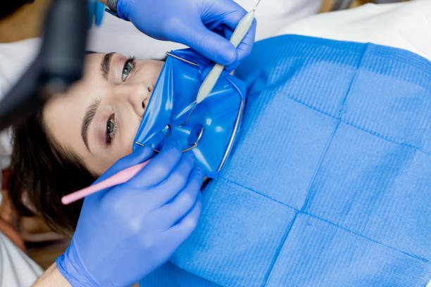 ein zahnarzt behandelt die zähne einer frau mit einem kofferdamm. zahnmedizinische geräte - handpiece stock-fotos und bilder