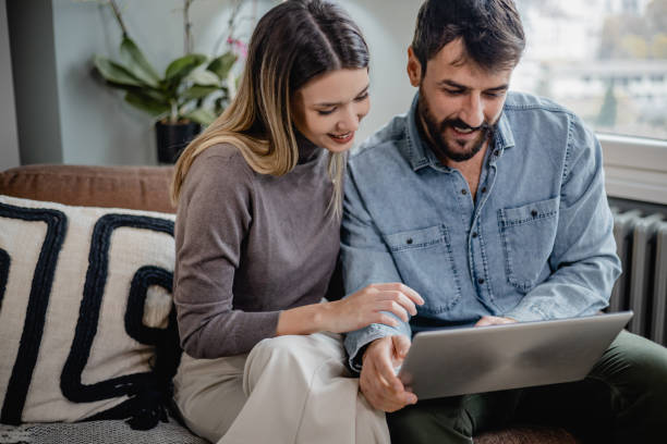 istock Young couple using laptop at home 1389376663