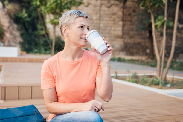 istock Woman drinking coffee from a reusable cup 1389380800