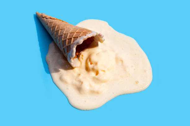 istock Melting ice cream balls with waffle cone on blue background. 1389398029