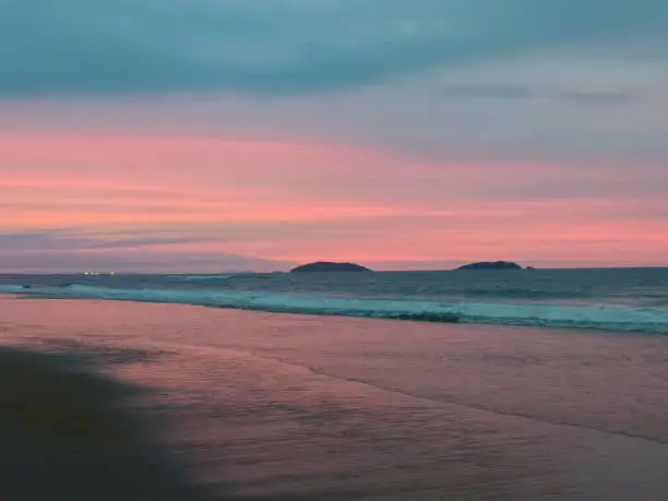 Beautiful beach landscape at dusk with its peculiar beauty and color. A spectacle of nature with its beautiful and unmistakable colors. Photo taken at Ervino beach in beautiful São Francisco do Sul, Santa Catarina, Brazil.