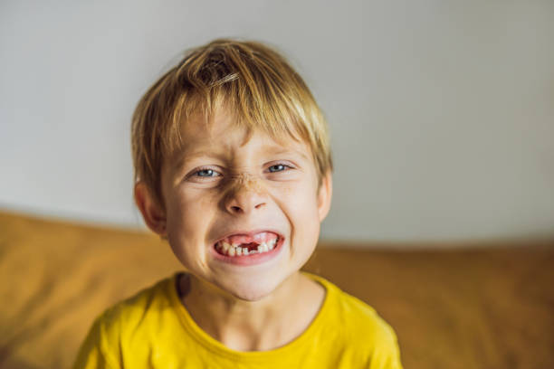 istock Litle caucasian boy shows that he lost his teeth 1389403300