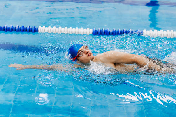 istock hispanic young man swimmer athlete wearing cap in a swimming training at the Pool in Mexico Latin America 1389408708