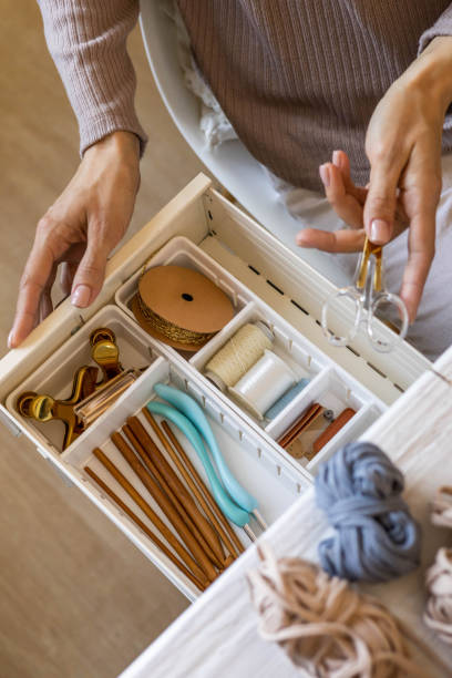 istock Female hands putting scissors into drawer with sewing accessories neatly placing organizing top view 1389410642