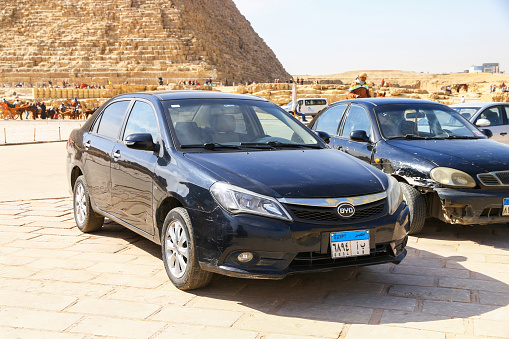 Giza, Egypt - January 26, 2021: Black Chinese sedan BYD F3 in a city street near the Pyramids.