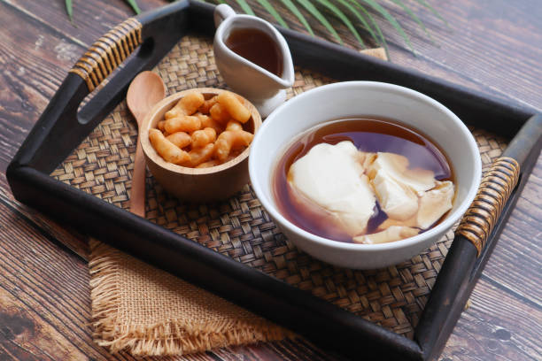 douhua - pudín de tofu suave (cuajada de soja), famoso postre saludable asiático servido en bandeja sobre mesa de madera a la vista de cerca - cuajar fotografías e imágenes de stock