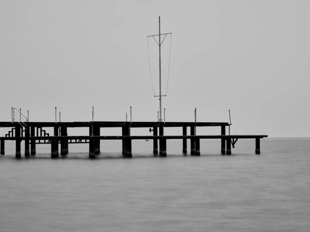 old pier on the beach and long exposure sea waves