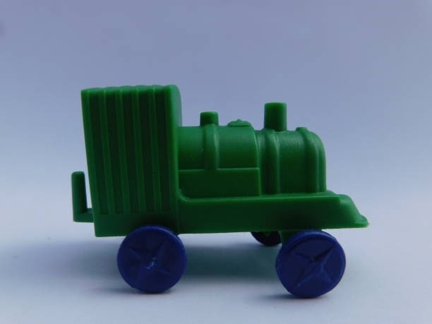 istock Green toy train, blue wheels isolated on white background 1389418593