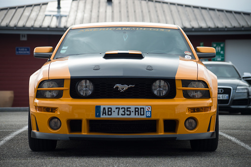 Lutterbach - France - 3 April 2022 - Front view of orange and black ford mustang 500 GT cars parked in the street