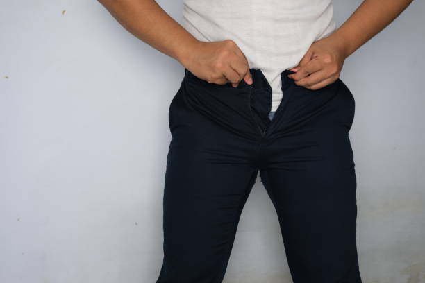 ズボンのボタン、肥満、たるんだ腹、プラスサイズに苦労している東南アジアの太った男 - abdomen too small jeans overweight ストックフォトと画像