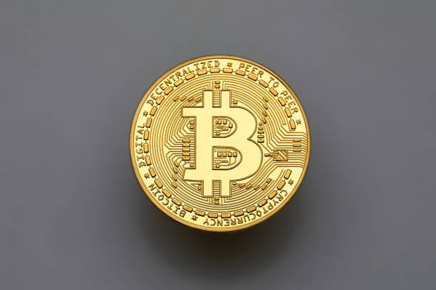 Single bitcoin on gray background, from above stock photo