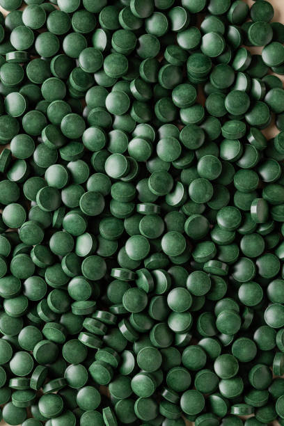 istock Spirulina green algae tablets close up. Dietary Supplement 1389427419