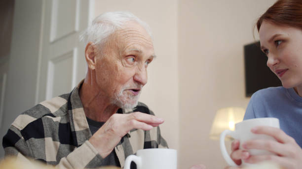 istock Woman drinking tea and talking to her elderly father 1389432762
