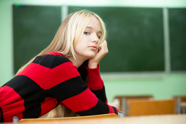 un'adolescente giace su un banco di scuola. studente di scuola superiore. ragazza di quindici anni. - sleeping high school desk education foto e immagini stock