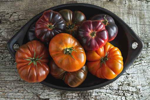 Tray with raf tomatoes and blue sea on old wood background. Copy space. Top view.