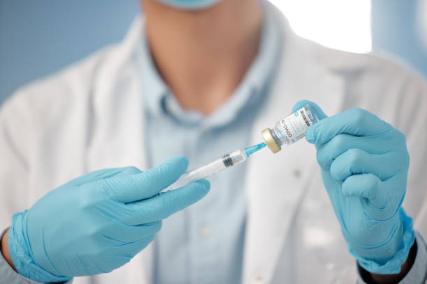 istock Shot of a lab technician filling a needle with fluid 1389436579