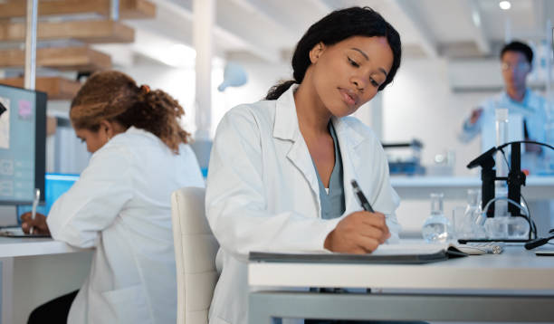 istock Shot of a young woman making notes while working in a lab 1389437201
