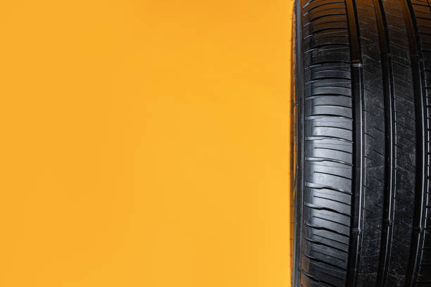 istock Car tires isolated on yellow background, close up 1389437500