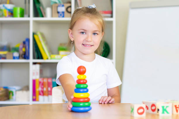 developmental and speech therapy classes with a child-girl. Speech therapy exercises and games with a colored pyramid developmental and speech therapy classes with a child-girl. Speech therapy exercises and games with a colored pyramid Online Montessori Training stock pictures, royalty-free photos & images