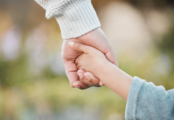 istock Shot of a man holding his son's hand while walking outside 1389438510