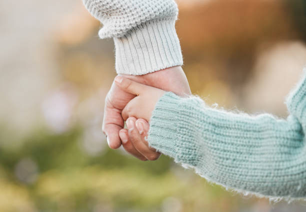 istock Shot of a man holding his daughter's hand while walking outside 1389438513