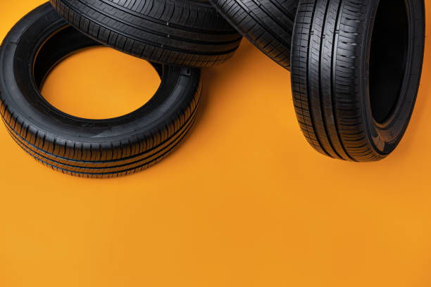 istock Car tires isolated on yellow background, close up 1389441347