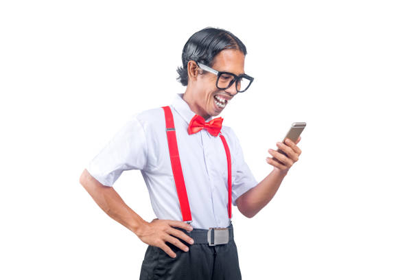 nerd asiático con una cara fea sosteniendo el teléfono móvil - bizarre nerd humor telephone fotografías e imágenes de stock