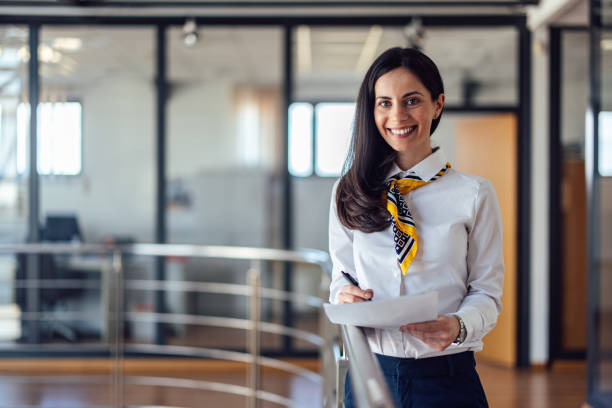 istock An elegantly dressed brunette woman, smiling at the camera, taki 1389442068